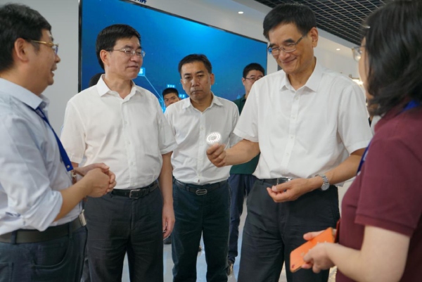 熊建同等带领一行细心观赏动物成长灯